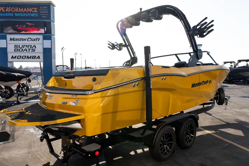 Slide: The Image of 2026 MasterCraft NXT23 yellow boat on trailer at marine dealership. - 38