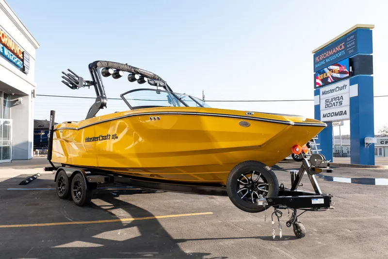 Slide: The Image of 2026 MasterCraft NXT23 boat in vibrant yellow on trailer at dealership. - 39