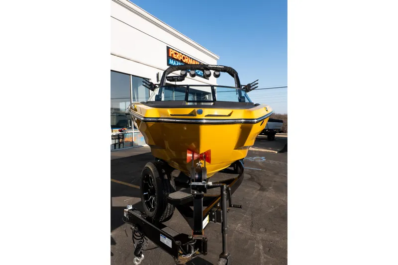 Slide: The Image of 2026 MasterCraft NXT23 boat in vibrant yellow on a trailer outside a dealership. - 40