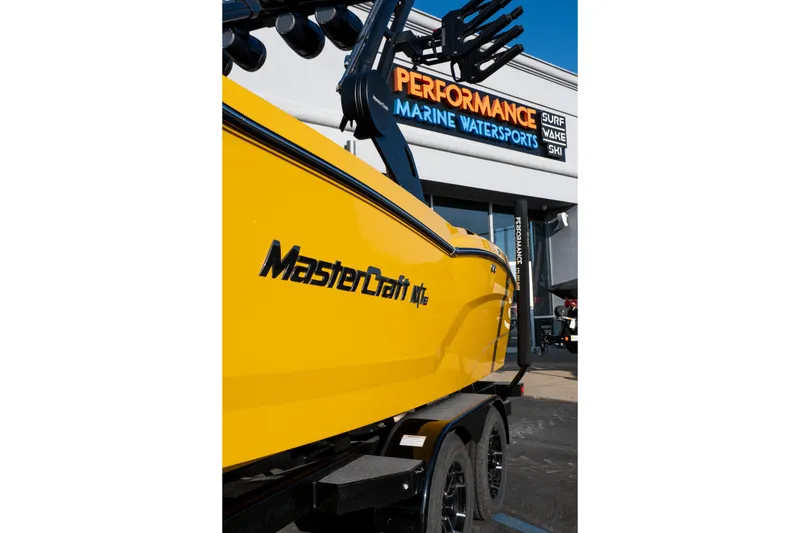 Slide: The Image of Yellow 2026 MasterCraft NXT23 boat at Performance Marine Watersports dealership. - 42