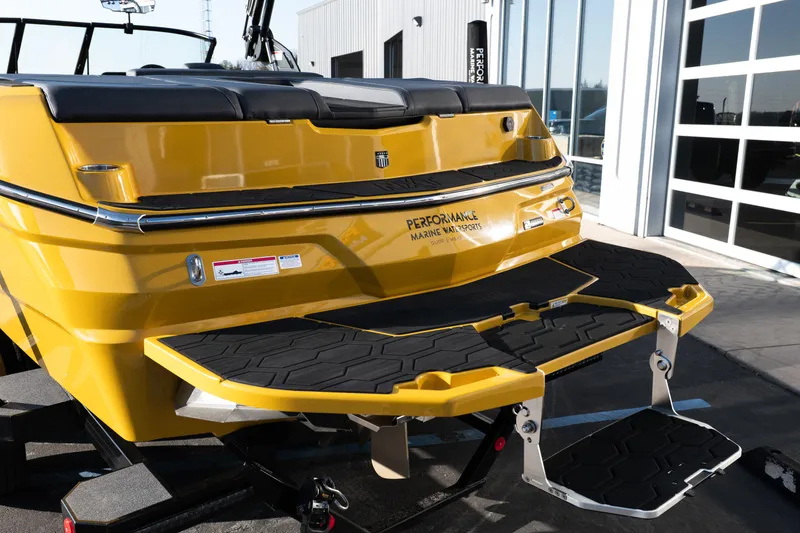 Slide: The Image of 2026 MasterCraft NXT23 boat with yellow exterior and black swim platform. - 6