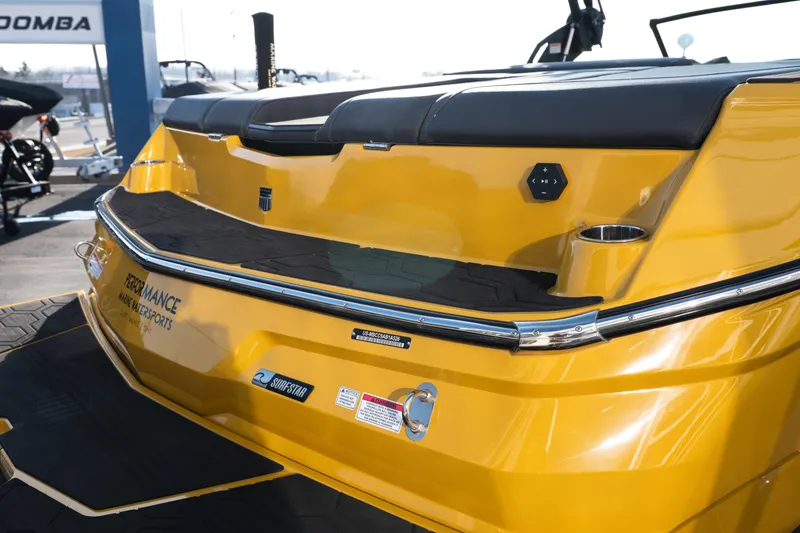 Slide: The Image of 2026 MasterCraft NXT23 boat, yellow exterior, rear view with seating and cup holders. - 7