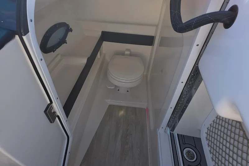 Slide: The Image of 2021 Formula 270 Bowrider interior with compact marine toilet and porthole window. - 31
