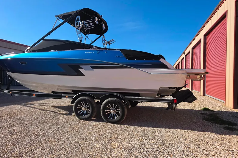Slide: The Image of 2021 Formula 270 Bowrider boat on trailer, parked near storage units. - 4
