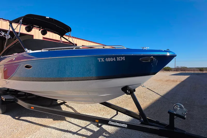 Slide: The Image of 2021 Formula 270 Bowrider boat on trailer, blue hull, sunny day. - 8