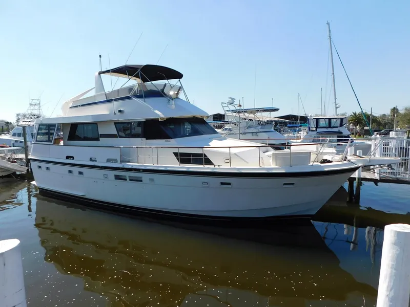 The Image of 1987 Hatteras 54 Motoryacht docked in a marina under clear blue skies. - 0