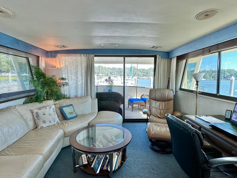 Slide: The Image of Luxurious interior of 1987 Hatteras 54 Motoryacht with leather seating and marina view. - 12
