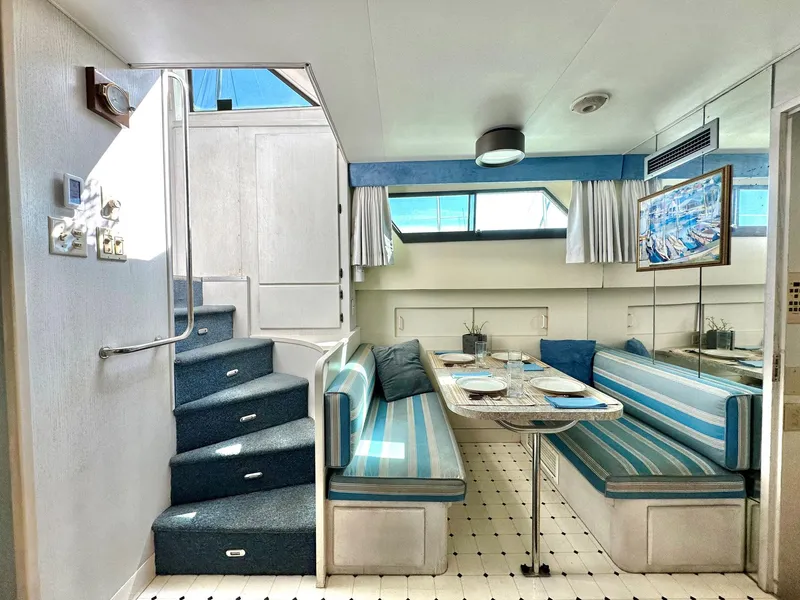 Slide: The Image of Interior of 1987 Hatteras 54 Motoryacht with striped seating and dining area. - 20