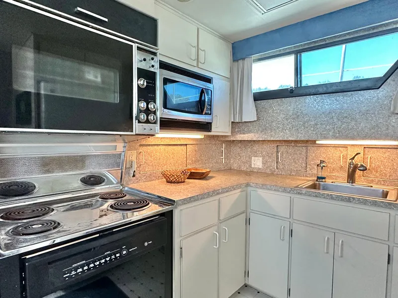 Slide: The Image of Kitchen interior of 1987 Hatteras 54 Motoryacht with stove, microwave, and sink. - 23