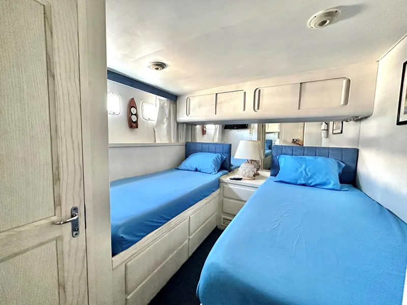 Slide: The Image of Twin bedroom in 1987 Hatteras 54 Motoryacht with blue bedding and wooden cabinetry. - 30
