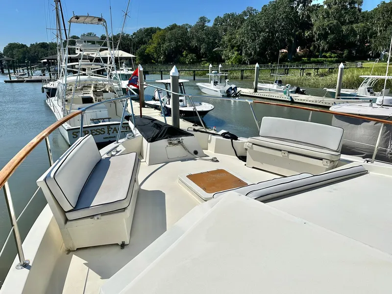 Slide: The Image of 1987 Hatteras 54 Motoryacht docked, featuring spacious deck seating and elegant design. - 33