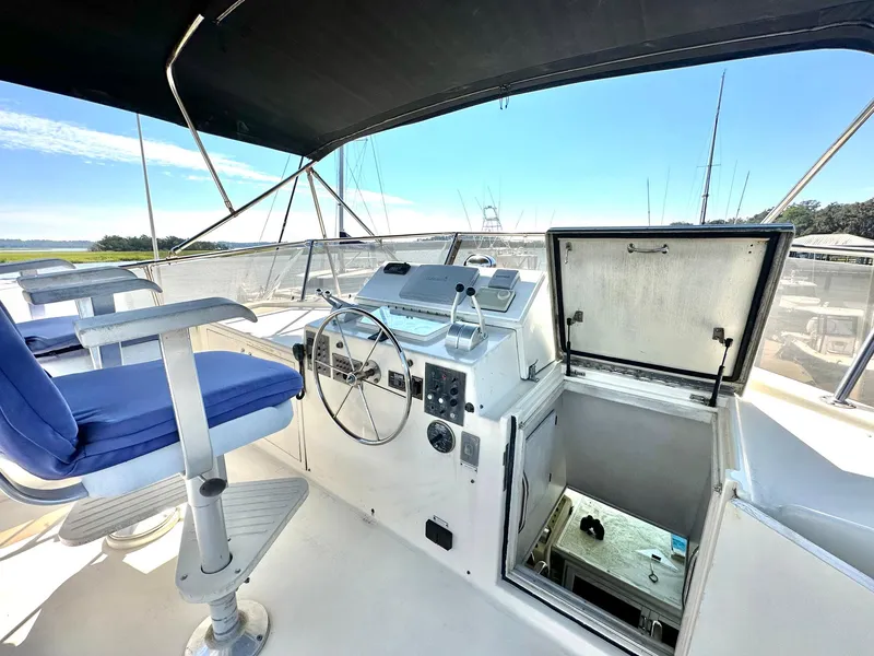 Slide: The Image of 1987 Hatteras 54 Motoryacht helm with blue captain's chair and open hatch. - 35