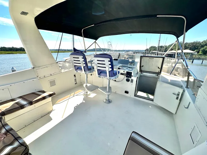 Slide: The Image of 1987 Hatteras 54 Motoryacht deck with seating, helm chairs, and water view. - 38