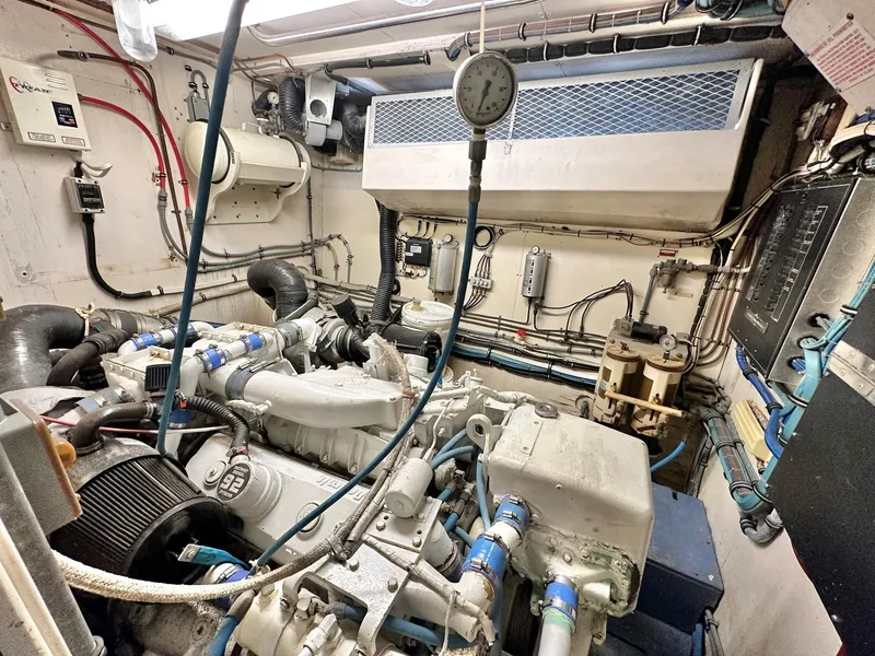 Slide: The Image of Engine room of a 1987 Hatteras 54 Motoryacht, showcasing mechanical components and wiring. - 39
