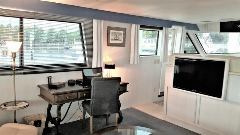Slide: The Image of Interior of 1987 Hatteras 54 Motoryacht with desk, chair, and TV, featuring large windows. - 5