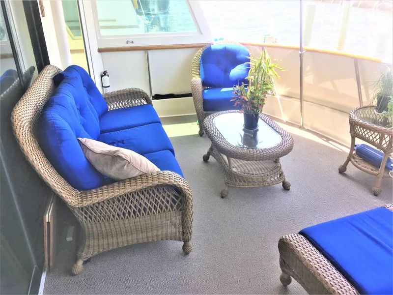 Slide: The Image of 1987 Hatteras 54 Motoryacht deck with wicker furniture and blue cushions. - 8