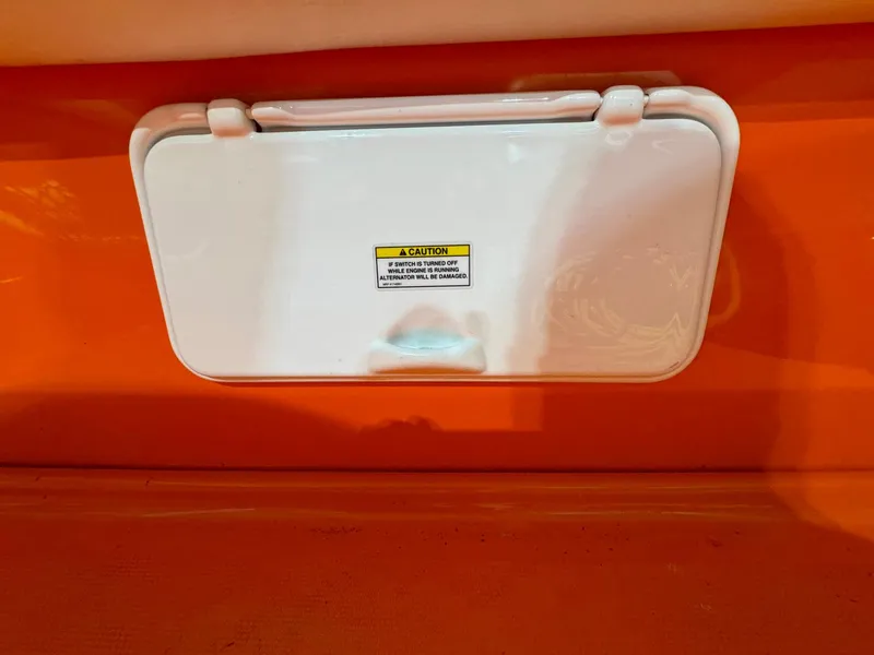 Slide: The Image of 2007 Baja 35 Outlaw boat compartment with caution label, orange interior. - 11