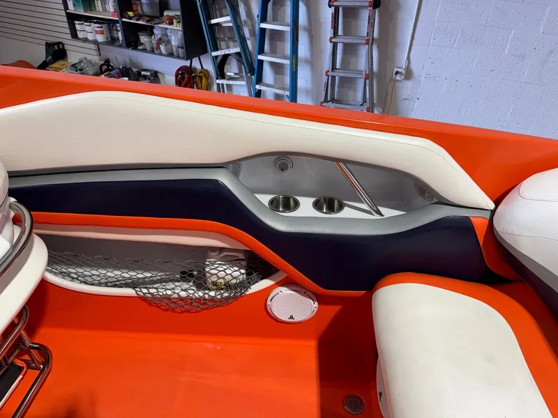 Slide: The Image of 2007 Baja 35 Outlaw boat interior with orange and white seating, cup holders, and storage net. - 24