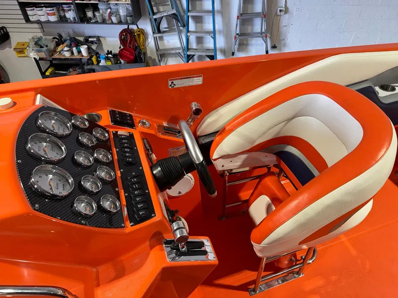 Slide: The Image of 2007 Baja 35 Outlaw boat cockpit with orange and white seating, control panel, and gauges. - 26