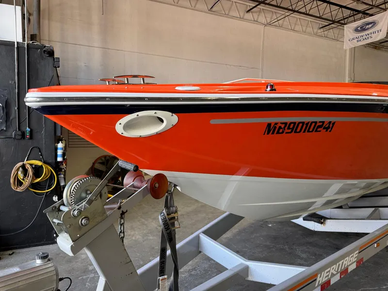Slide: The Image of 2007 Baja 35 Outlaw boat in vibrant orange on a trailer in a garage. - 3