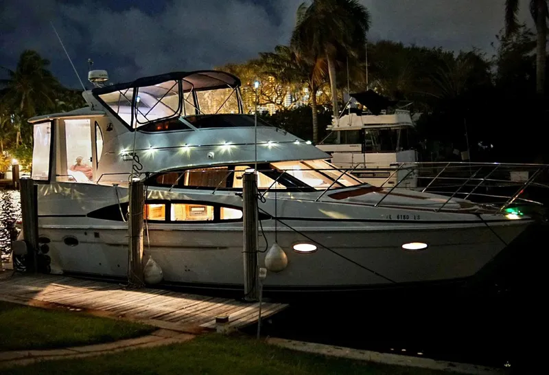 Slide: The Image of 2001 Carver 396 Motor Yacht docked at night, illuminated with interior lights. - 12