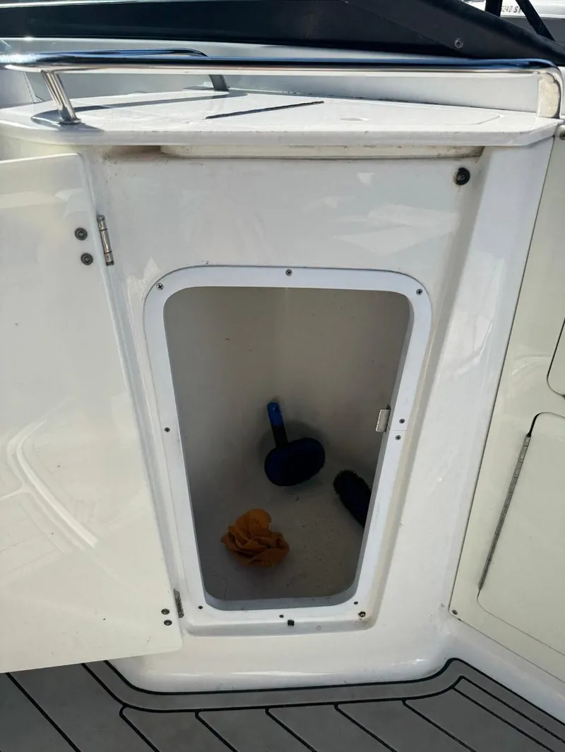 Slide: The Image of Open storage compartment on a 2020 Monterey M45 boat with cleaning supplies inside. - 21