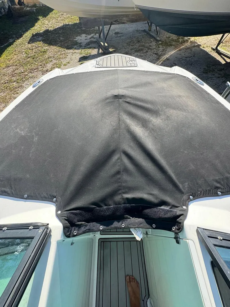 Slide: The Image of 2020 Monterey M45 boat with black cover, docked on land. - 23