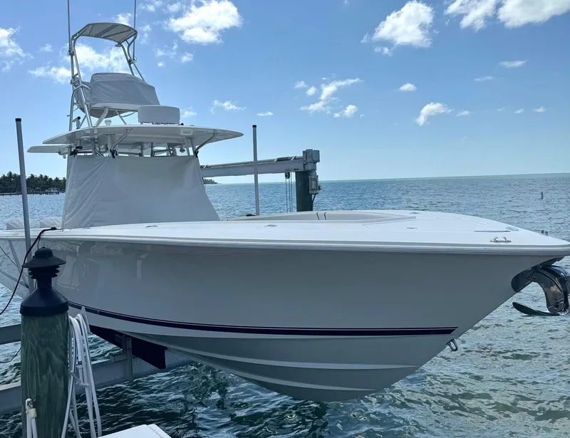 Slide: The Image of 2014 SeaVee 390B Center Console boat docked by the ocean under a clear blue sky. - 3