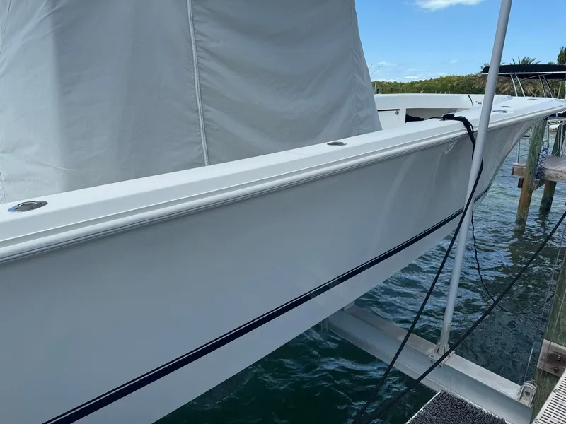 Slide: The Image of 2014 SeaVee 390B Center Console boat docked, side view with white hull and calm water. - 5