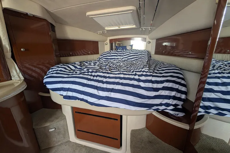 Slide: The Image of 2008 Sea Ray 340 Sundancer cabin with striped bedding and wooden cabinetry. - 10