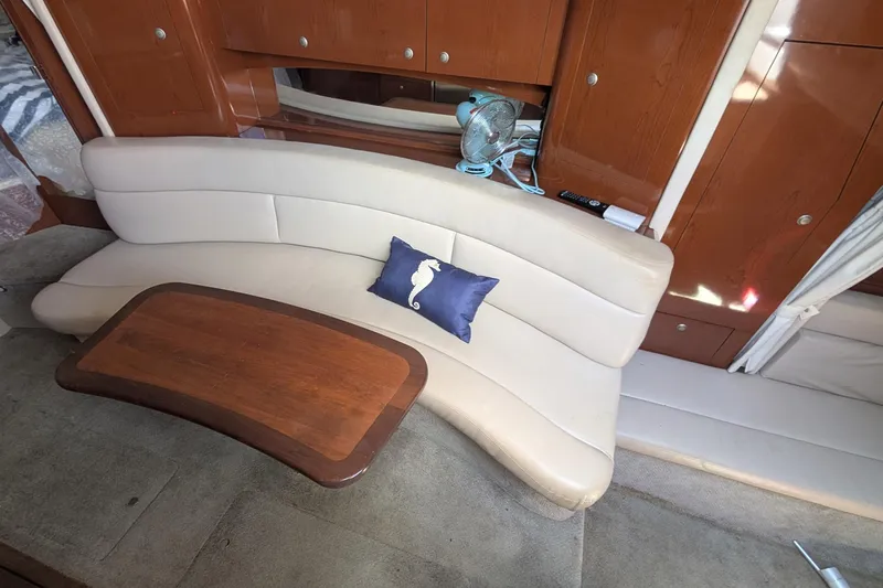 Slide: The Image of Interior of 2008 Sea Ray 340 Sundancer with curved seating and wooden table. - 11