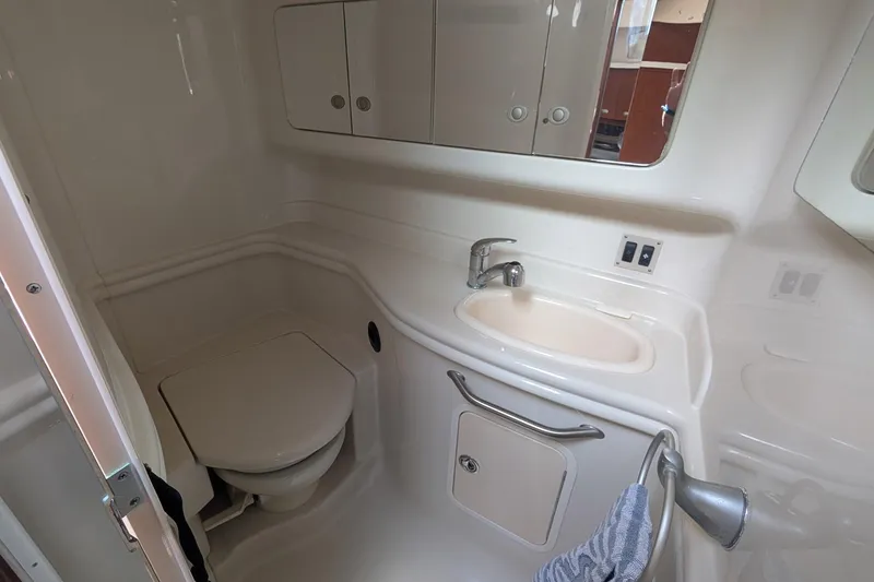 Slide: The Image of 2008 Sea Ray 340 Sundancer bathroom with sink, toilet, and storage cabinets. - 15