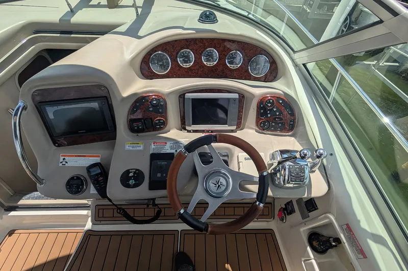 Slide: The Image of 2008 Sea Ray 340 Sundancer helm with gauges, steering wheel, and navigation controls. - 3