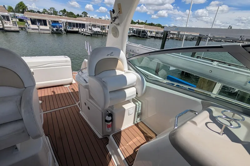 Slide: The Image of 2008 Sea Ray 340 Sundancer boat interior with plush seating and wooden deck. - 9