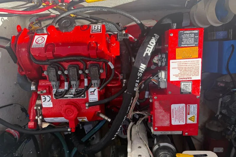 Slide: The Image of Engine compartment of a 2017 Fountain 38 Sportfish Cruiser with red engine components. - 11