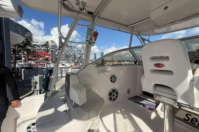 Slide: The Image of 2017 Fountain 38 Sportfish Cruiser interior with seating and controls, docked at marina. - 26