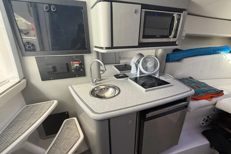 Slide: The Image of 2017 Fountain 38 Sportfish Cruiser interior with kitchenette, featuring sink, stove, and microwave. - 43