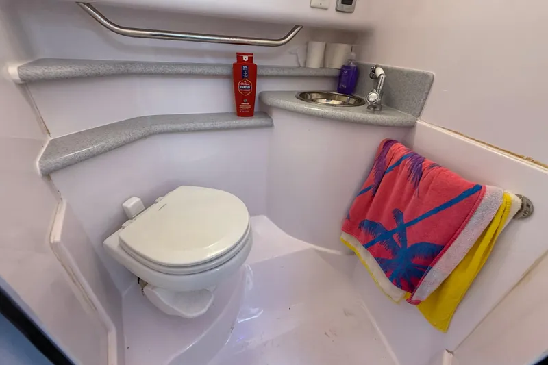 Slide: The Image of Compact bathroom in 2017 Fountain 38 Sportfish Cruiser with toilet, sink, and colorful towel. - 53