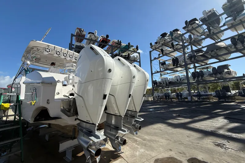 Slide: The Image of 2017 Fountain 38 Sportfish Cruiser with triple outboard engines in a boat storage facility. - 64