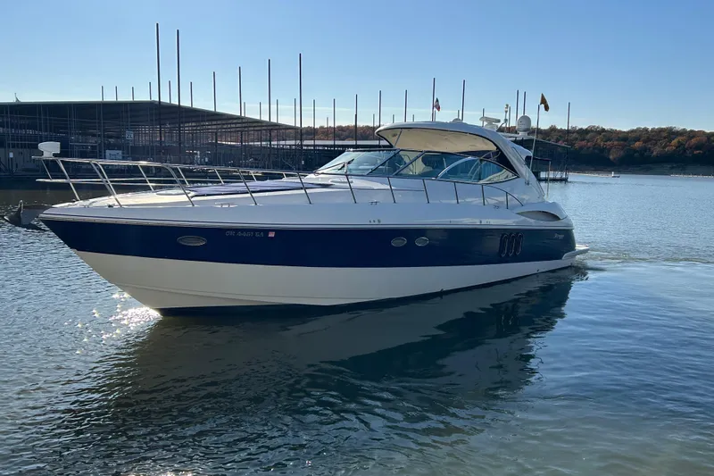 Slide: The Image of 2005 Cruisers 500 yacht on calm water near a marina, under clear blue sky. - 3