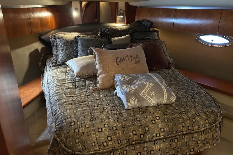 Slide: The Image of Luxurious 2005 Cruisers 500 yacht bedroom with cozy bedding and elegant wood paneling. - 32