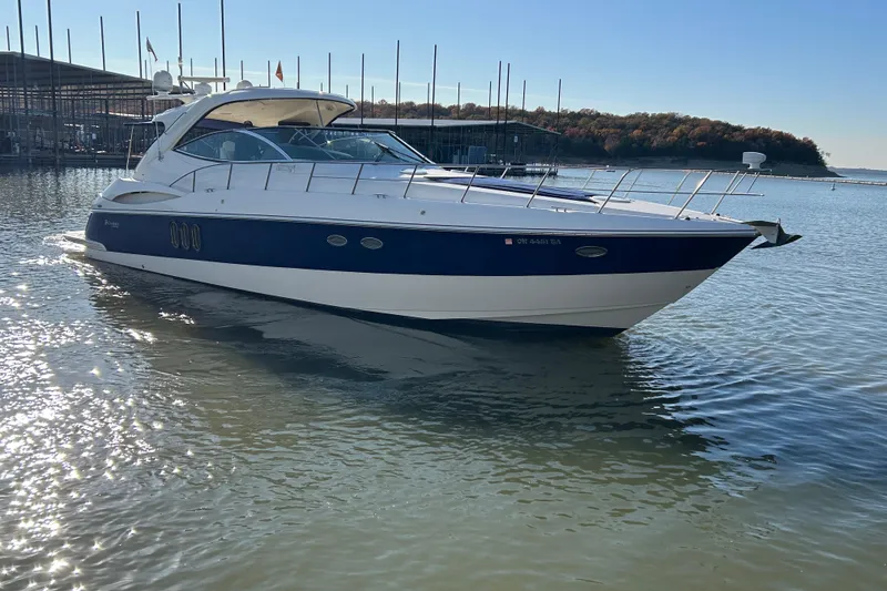 Slide: The Image of 2005 Cruisers 500 yacht on calm water near a marina, under clear blue sky. - 41