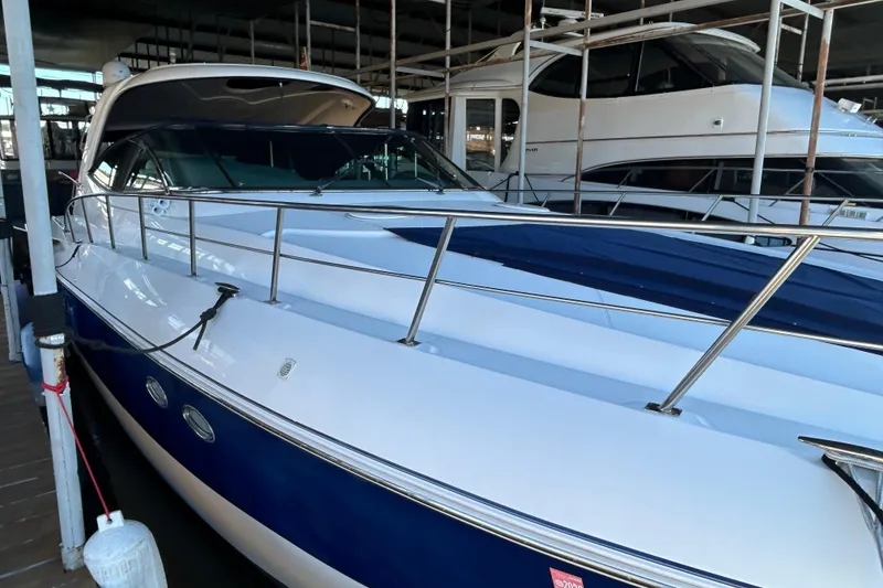 Slide: The Image of 2005 Cruisers 500 yacht docked in marina, featuring sleek design and blue accents. - 12