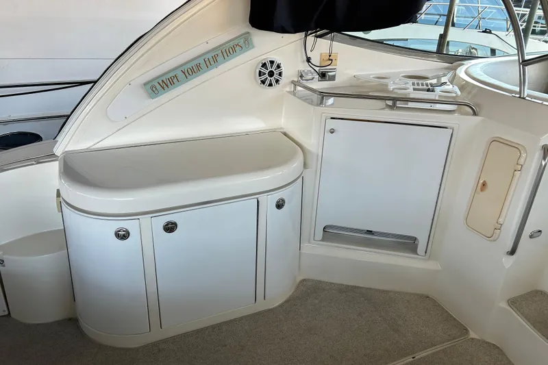 Slide: The Image of 2005 Cruisers 500 yacht interior with kitchenette and storage, featuring "Wipe Your Flip Flops" sign. - 17