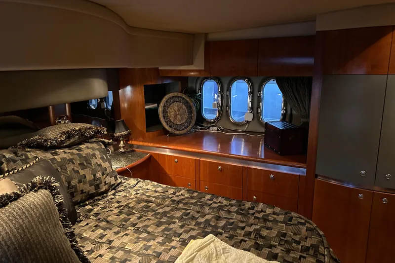 Slide: The Image of Luxurious 2005 Cruisers 500 yacht bedroom with elegant wood cabinetry and plush bedding. - 23