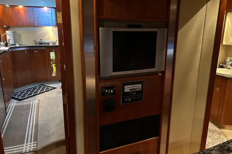 Slide: The Image of 2005 Cruisers 500 yacht interior with TV, stereo, and wooden cabinetry. - 25