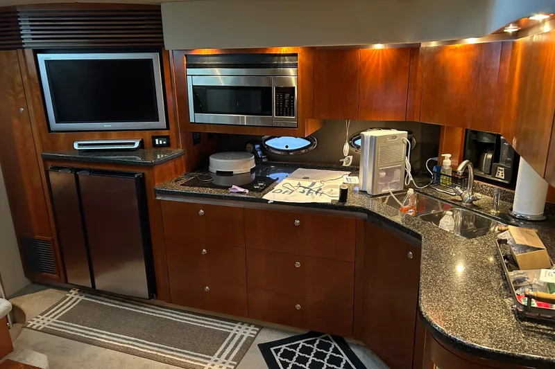 Slide: The Image of Luxurious 2005 Cruisers 500 yacht kitchen with modern appliances and sleek wood cabinetry. - 27