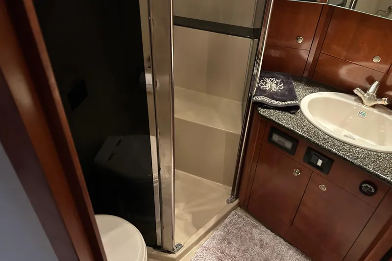 Slide: The Image of Luxurious 2005 Cruisers 500 yacht bathroom with shower, sink, and elegant wood cabinetry. - 31