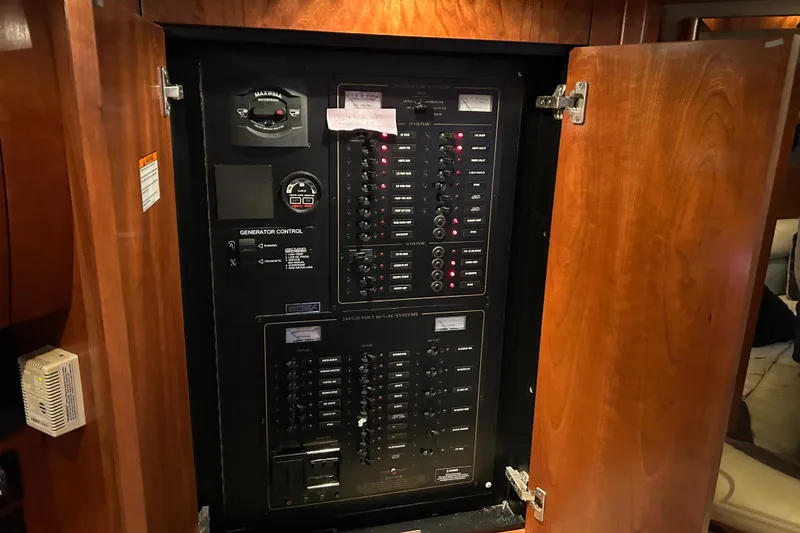 Slide: The Image of Electrical control panel inside a 2005 Cruisers 500 yacht, featuring generator controls. - 33
