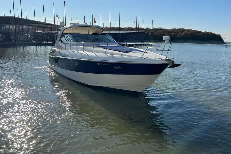 Slide: The Image of 2005 Cruisers 500 yacht on calm water near marina, under clear blue sky. - 39